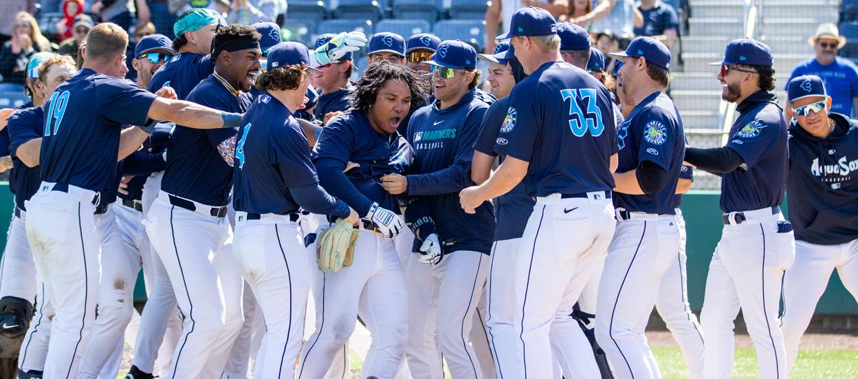 El colombiano Michael Arroyo es felicitado por sus compañeros tras llegar al plato. 
