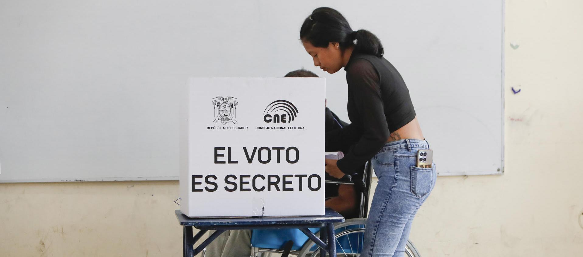 Un hombre en silla de ruedas marca su voto en un centro de votación este domingo, en Olón.