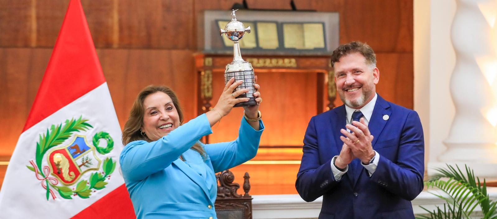 Dina Boluarte, presidenta de Perú, con el trofeo de la Copa Libertadores. A su lado, Alejandro Domínguez, titular de la Conmebol. 
