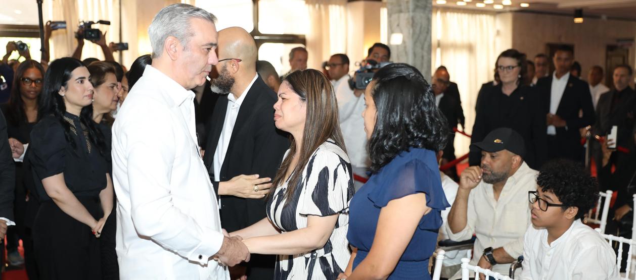 Zulinka Pérez, hija de Rubby Pérez, recibiendo las condolencias del presidente dominicano Luis Abinader. 