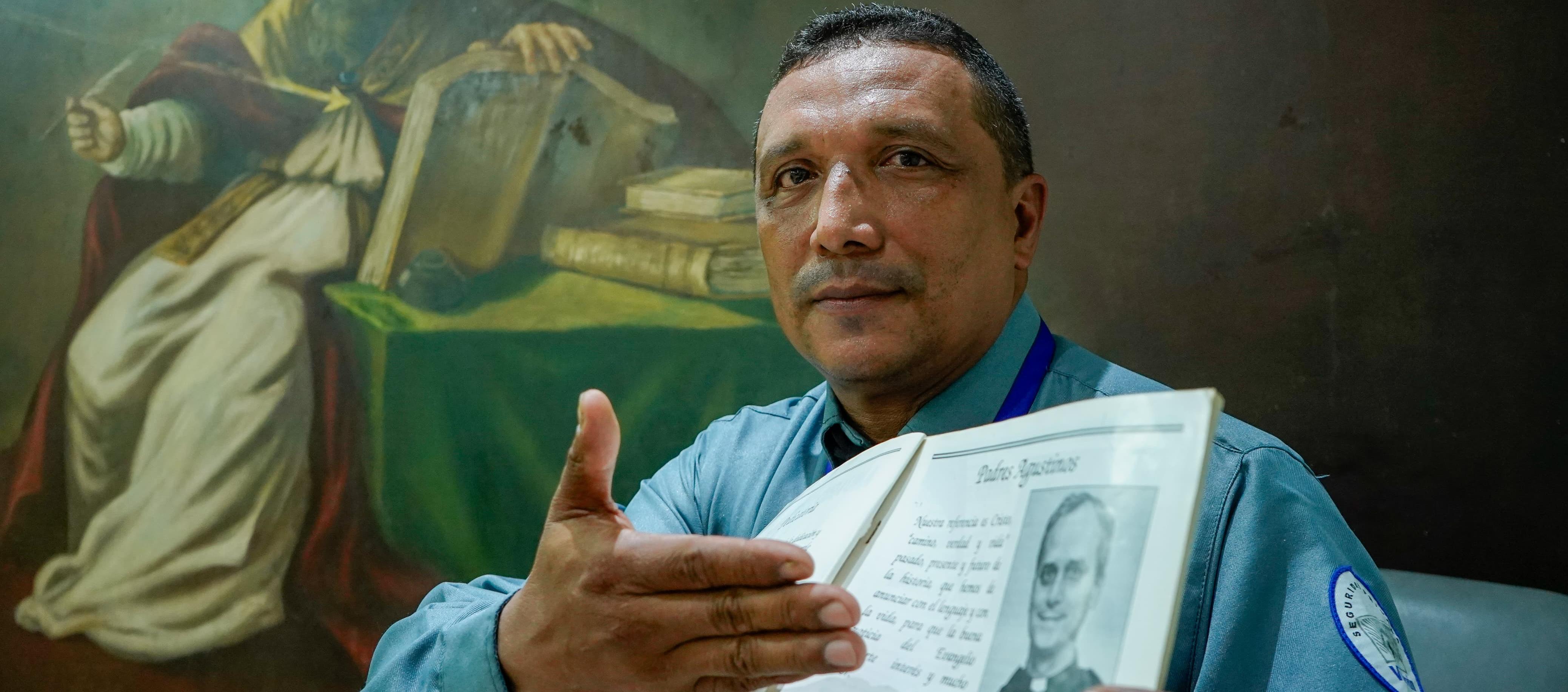 Jairo Enrique Padilla San Juan, guardia de seguridad del Colegio Liceo de Cervantes, junto al anuario del 2002 cuando el Papa León XIV visitó la institución.