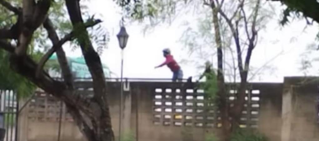 Momento en que varios hombres lanzaban piedras al parqueadero externo de la Universidad del Atlántico. 