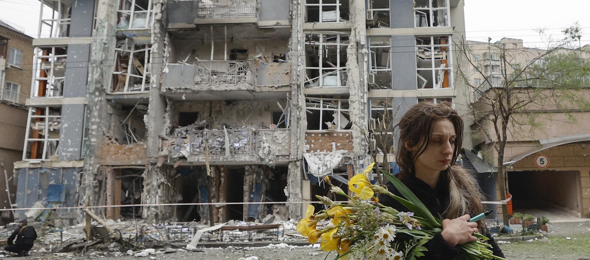 Mujer caminando junto a un edificio destruido tras el ataque nocturno. 