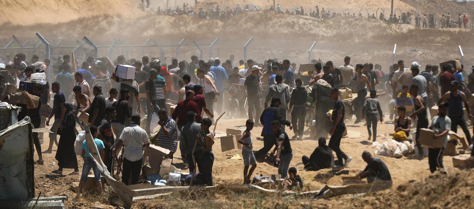 Palestinos transportan suministros de ayuda recibidos de la Fundación Humanitaria de Gaza.