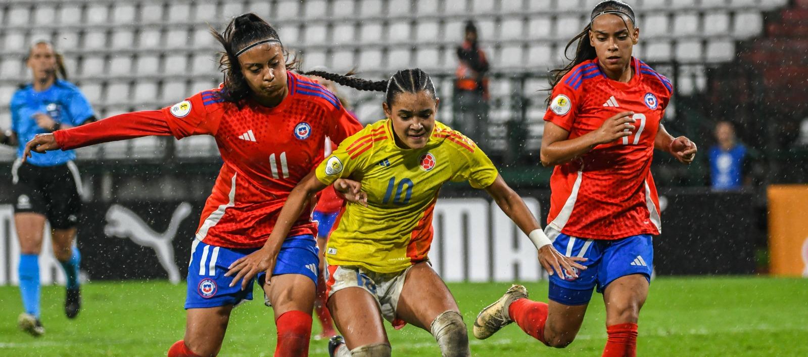 La colombiana Ella Grace Martínez intenta escaparse entre dos chilenas. 