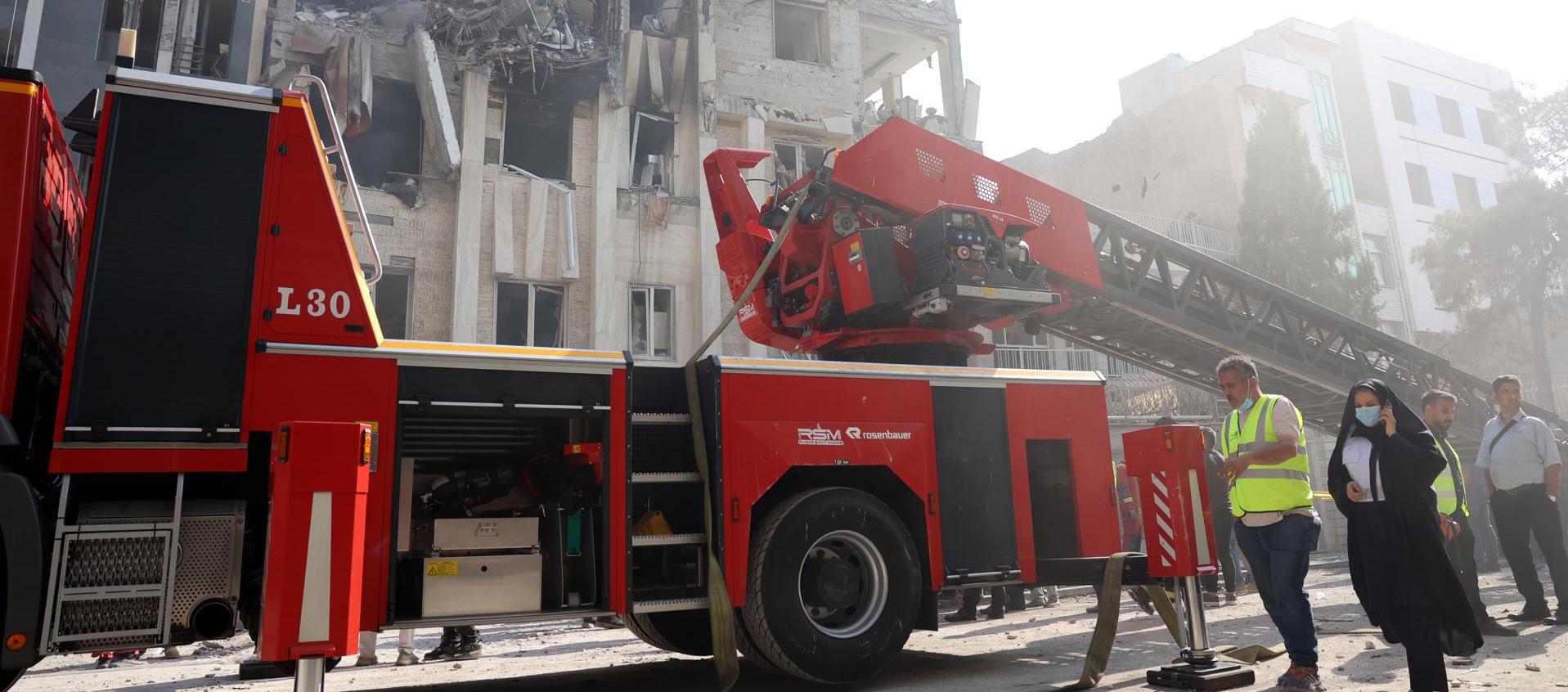 Los bomberos trabajan en un edificio alcanzado por ataques aéreos israelíes en el centro de Teherán.