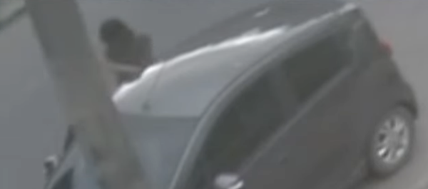 Menor subiéndose al Chevrolet Spark gris.