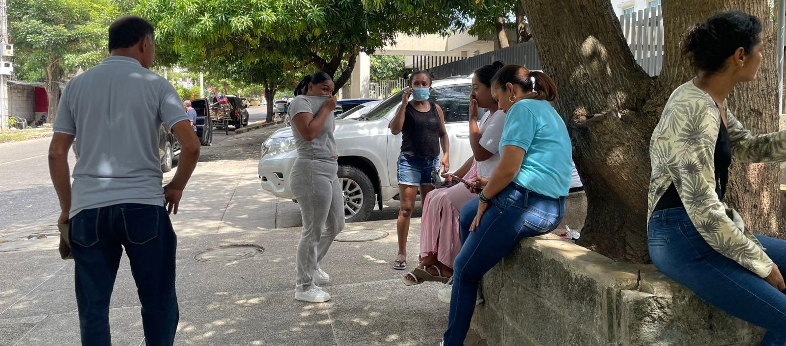 Personas en las afueras de la morgue se cubren ante el putrefacto olor que emana de la parte interior. 