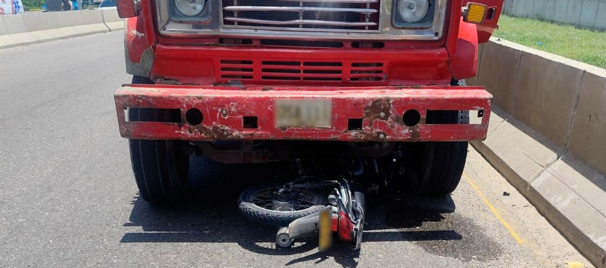 La motocicleta quedó debajo de la volqueta. 