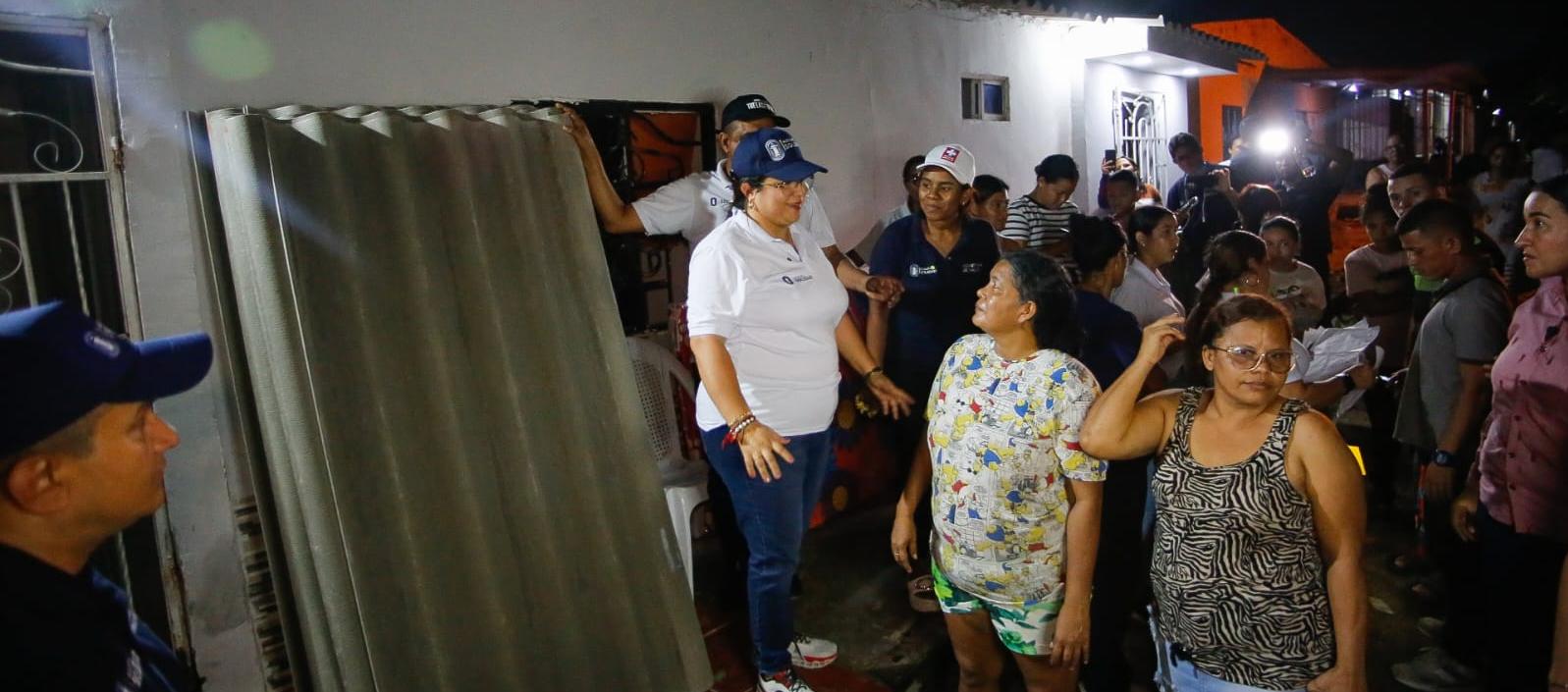 La alcaldesa Alcira Sandoval lidera la entrega de láminas a los afectados en la noche de este sábado. 