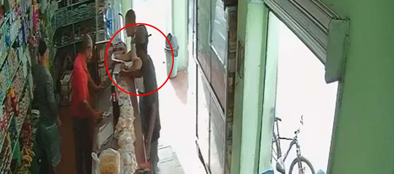 Momentos en que el joven dejaba un panfleto en una tienda en la tarde