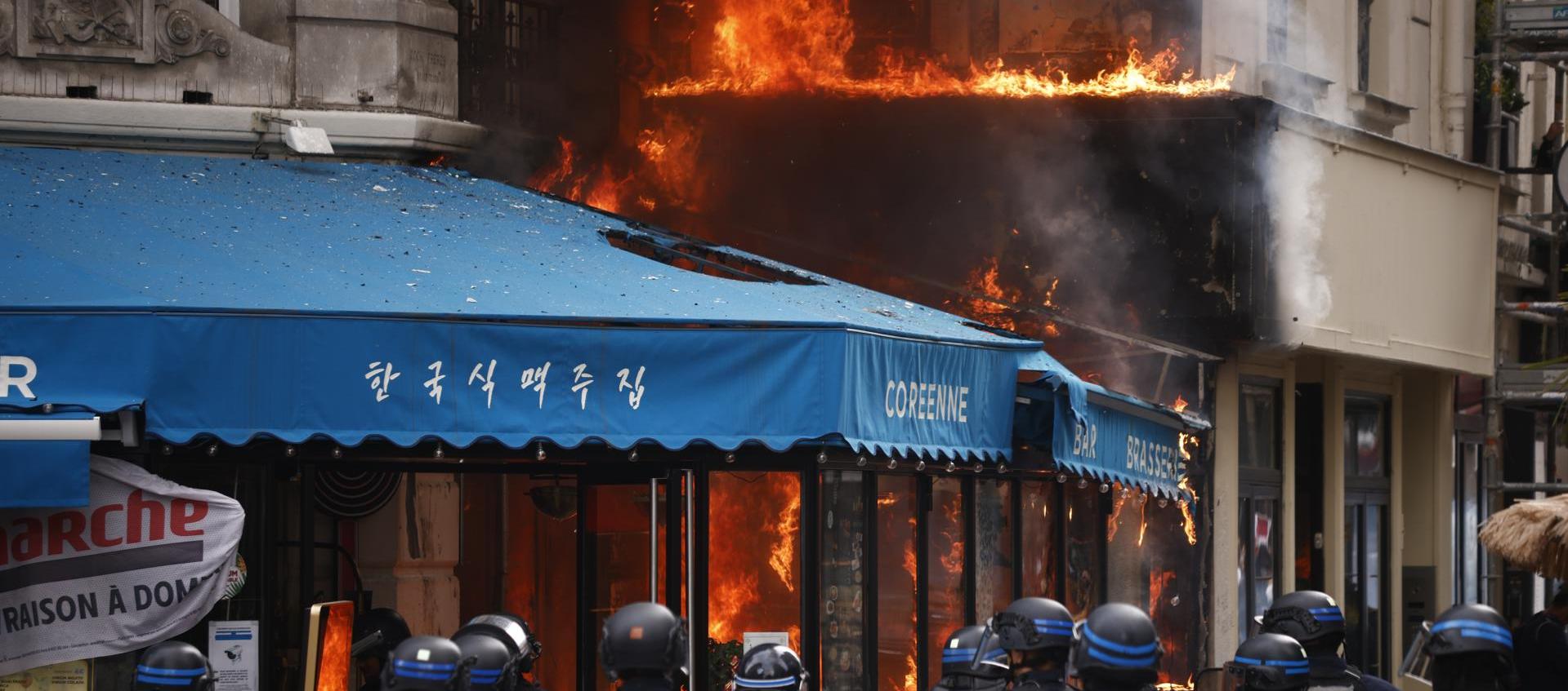 Agentes de policía aseguran alrededor de un restaurante en Paris tras ser incendiado.