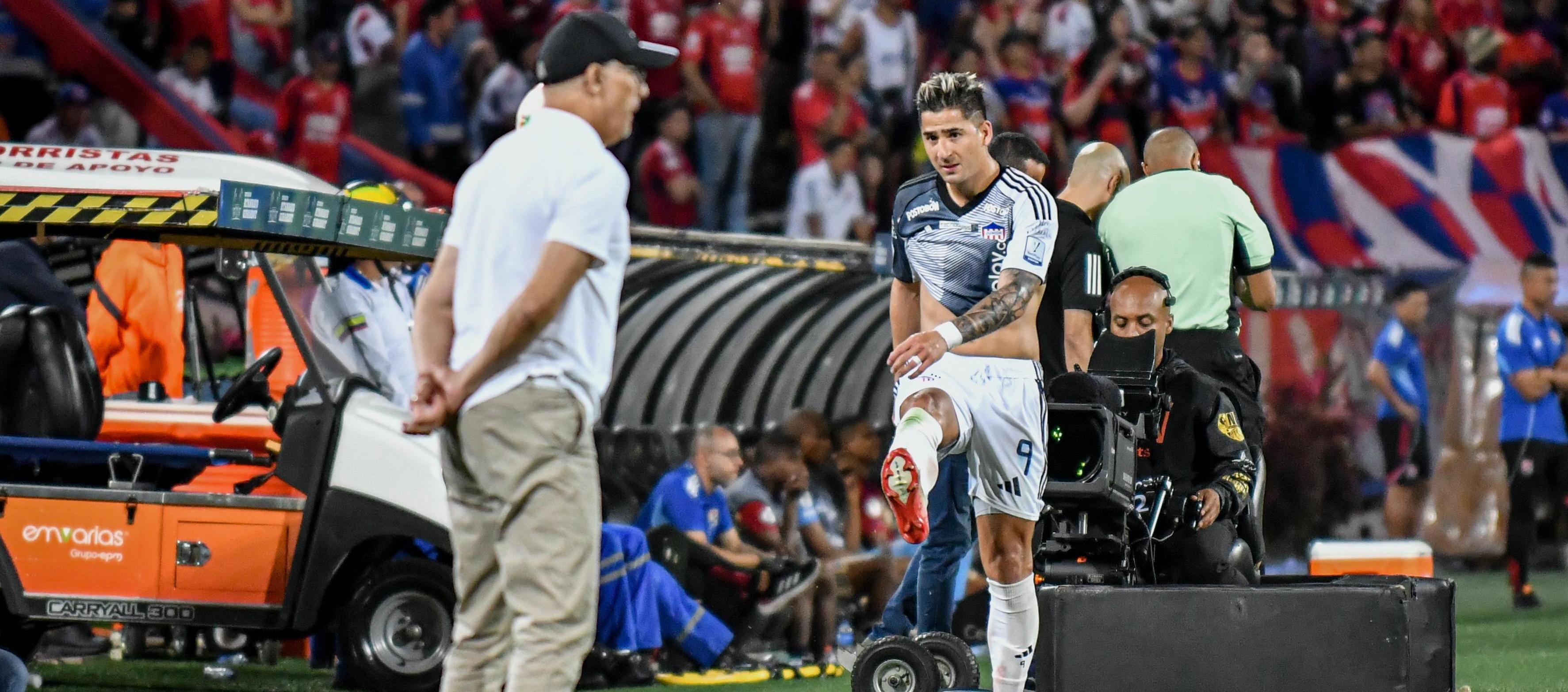 Guillermo Paiva se acerca al técnico Alfredo Arias tras ser sustituido en el partido contra el Medellín.