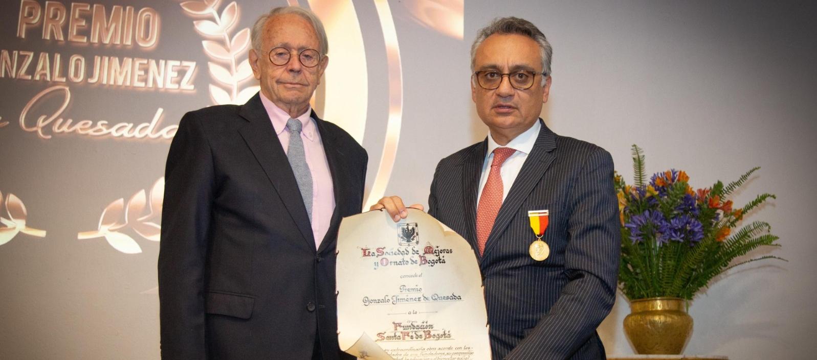 Henry Gallardo, director general de Fundación Santa Fe de Bogotá recibe el Premio Gonzalo Jiménez de Quesada 2025 en manos del presidente de la Sociedad de Mejoras y Ornato de Bogotá, Carlos Pombo Urdaneta. 