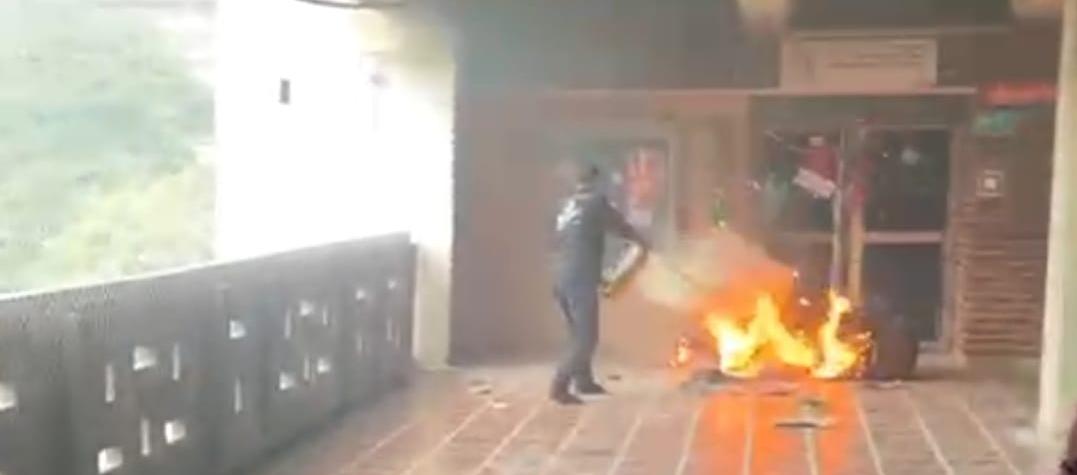 Personal de Uniatlántico mientras controla el incendio con un extintor.