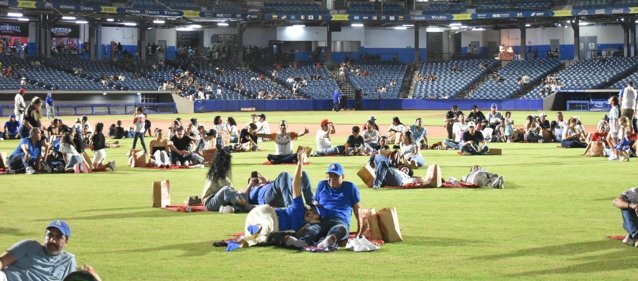 Aficionados en el terreno del juego del Édgar Rentería disfrutando de 'Picnic en el Diamante'.