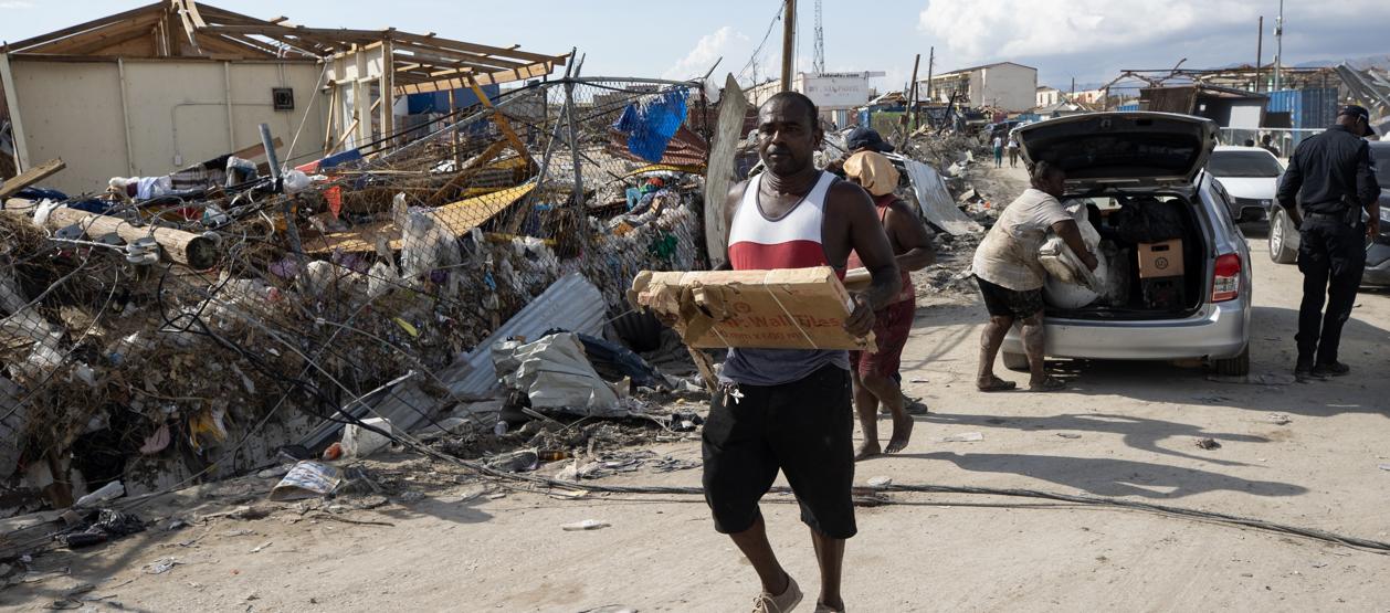 Personas afectadas por el paso del huracán Melissa recolectan objetos en Black River (Jamaica).