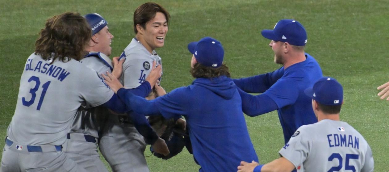 El lanzdor japonés Yoshinobu Yamamoto, Jugador Más Valioso de la Serie Mundial, es felicitado por sus compañeros al concluir el juego.