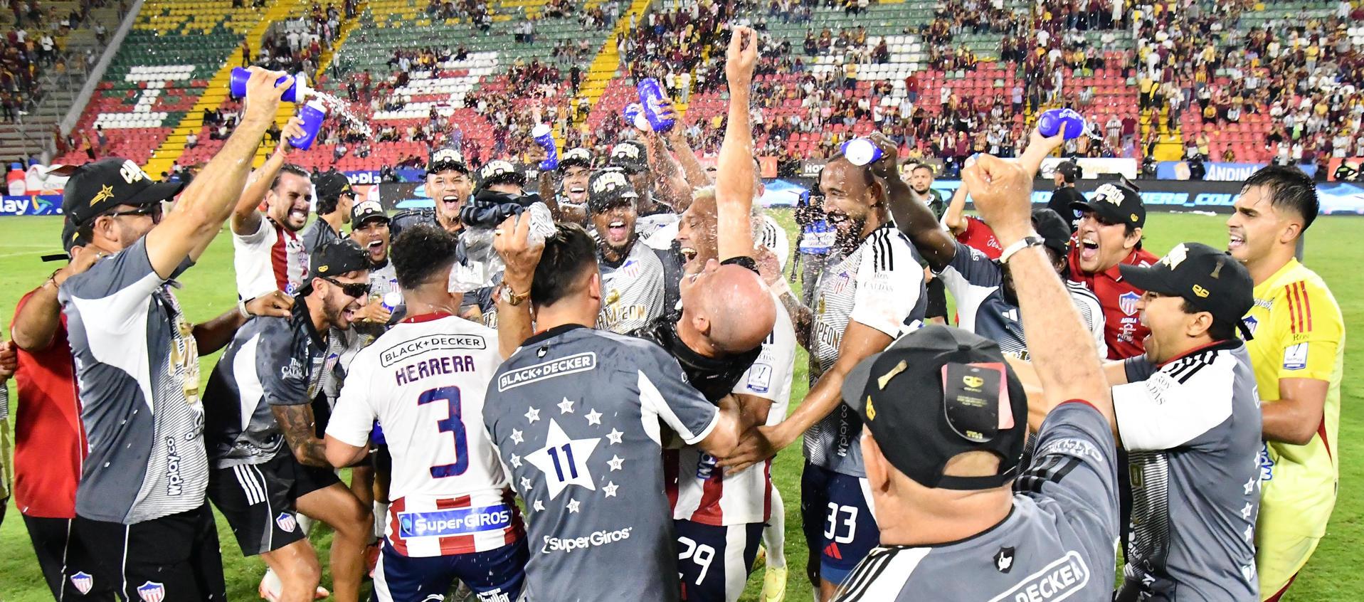 El técnico del Junior, Alfredo Arias, celebra el título con sus jugadores.