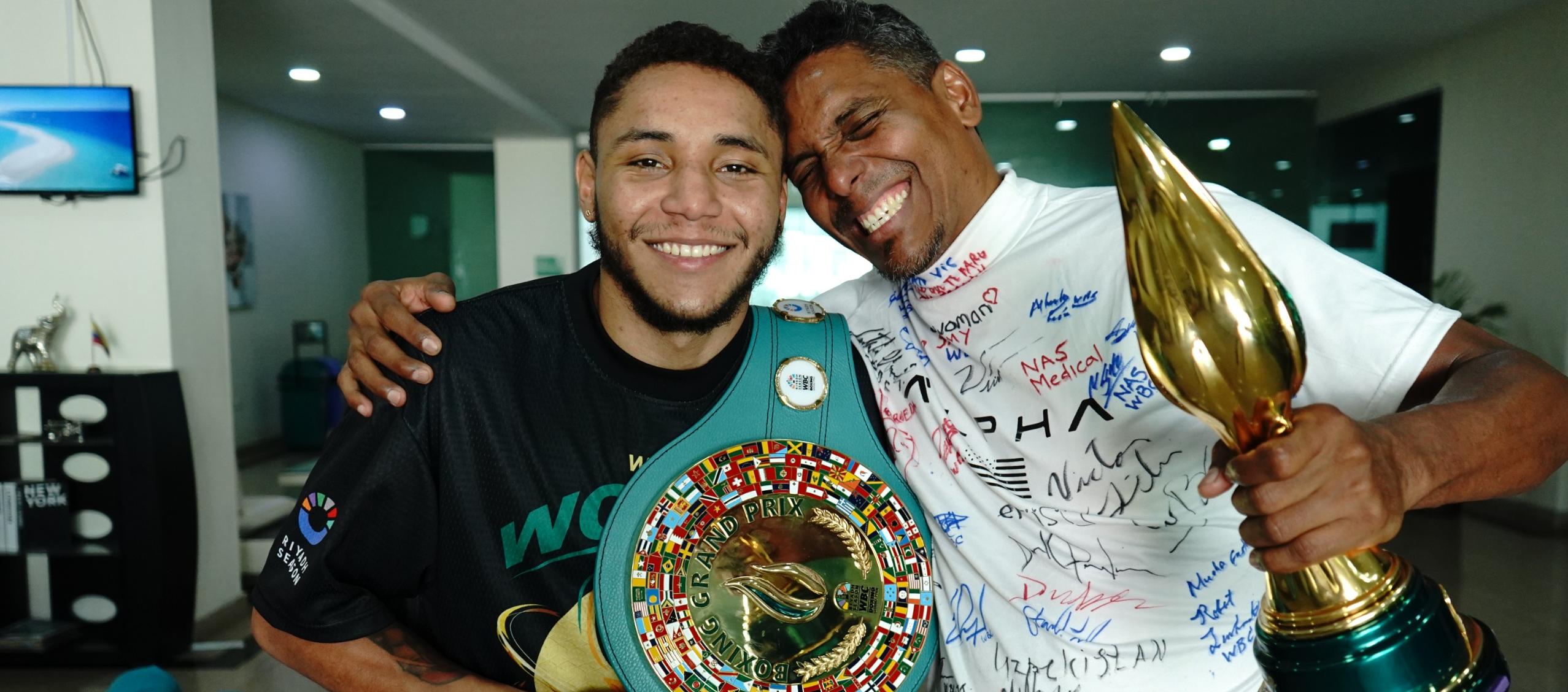 Carlos Utria con el cinturón de campeón y su papá y entrenador Lenin 