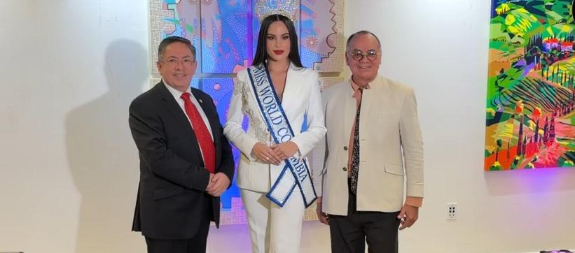 Andrea Romero, representante de Colombia al Miss Mundo, junto al cónsul Oscar Marmolejo (traje blanco).