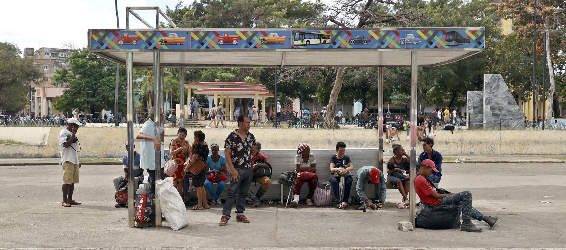 Personas esperan en un paradero de buses este martes, durante un apagón en La Habana. 