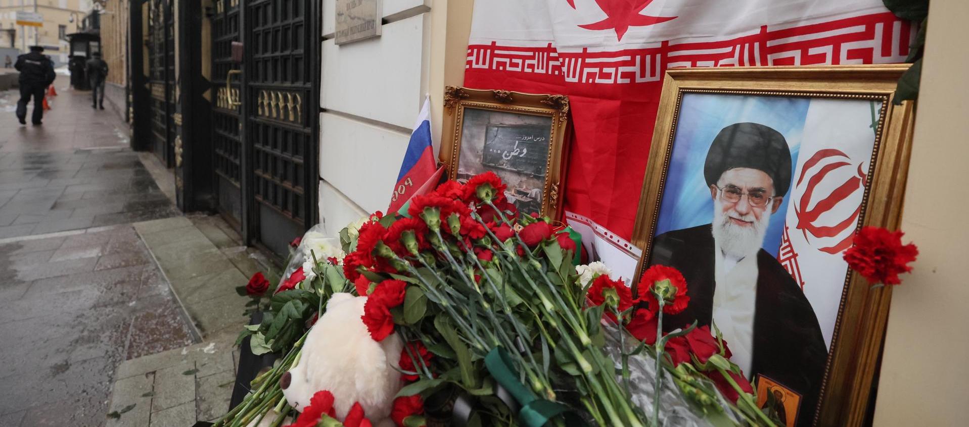 Flores y juguetes son colocados al lado del retrato del líder supremo de Irán, el ayatolá Ali Jameneí