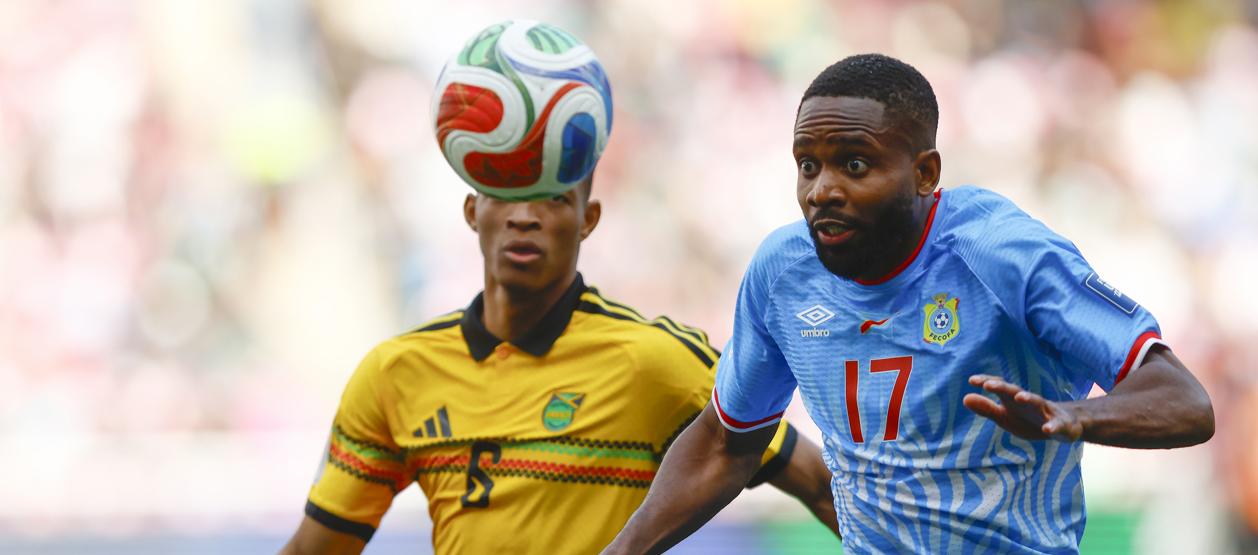 El congolés Cedric Bakambu disputa la pelota con el jamaiquino Richard King.