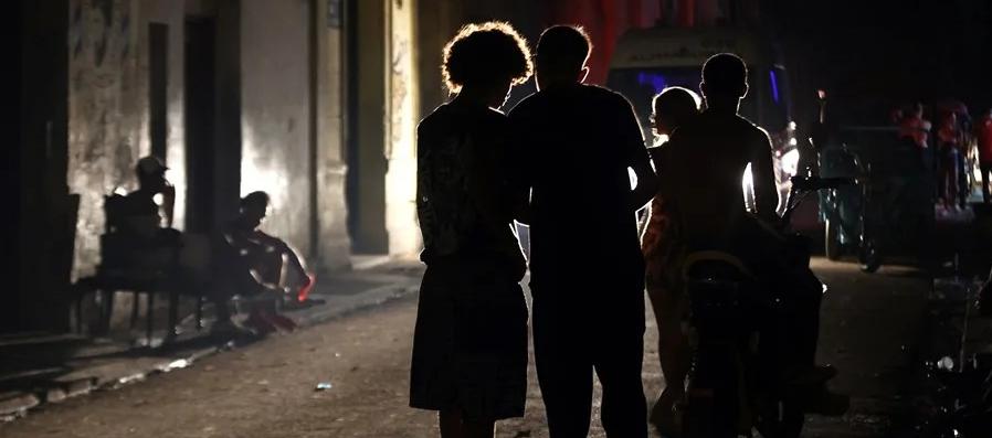 Personas hablan en una calle durante un apagón.