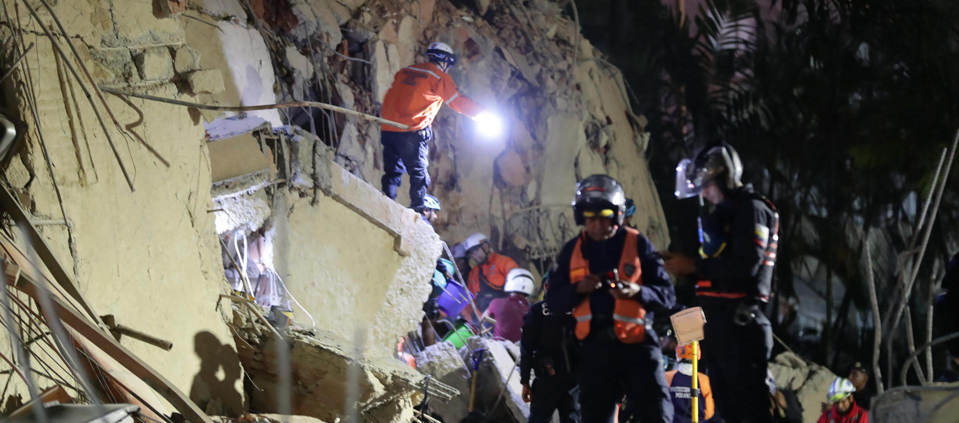 Integrantes de cuerpos de emergencia buscan víctimas.