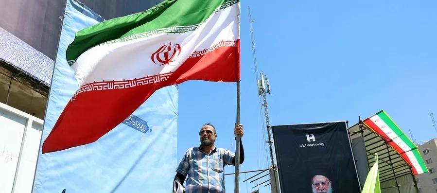Un iraní sosteniendo una bandera de su país, en la Plaza Valiasr, en Teherán.