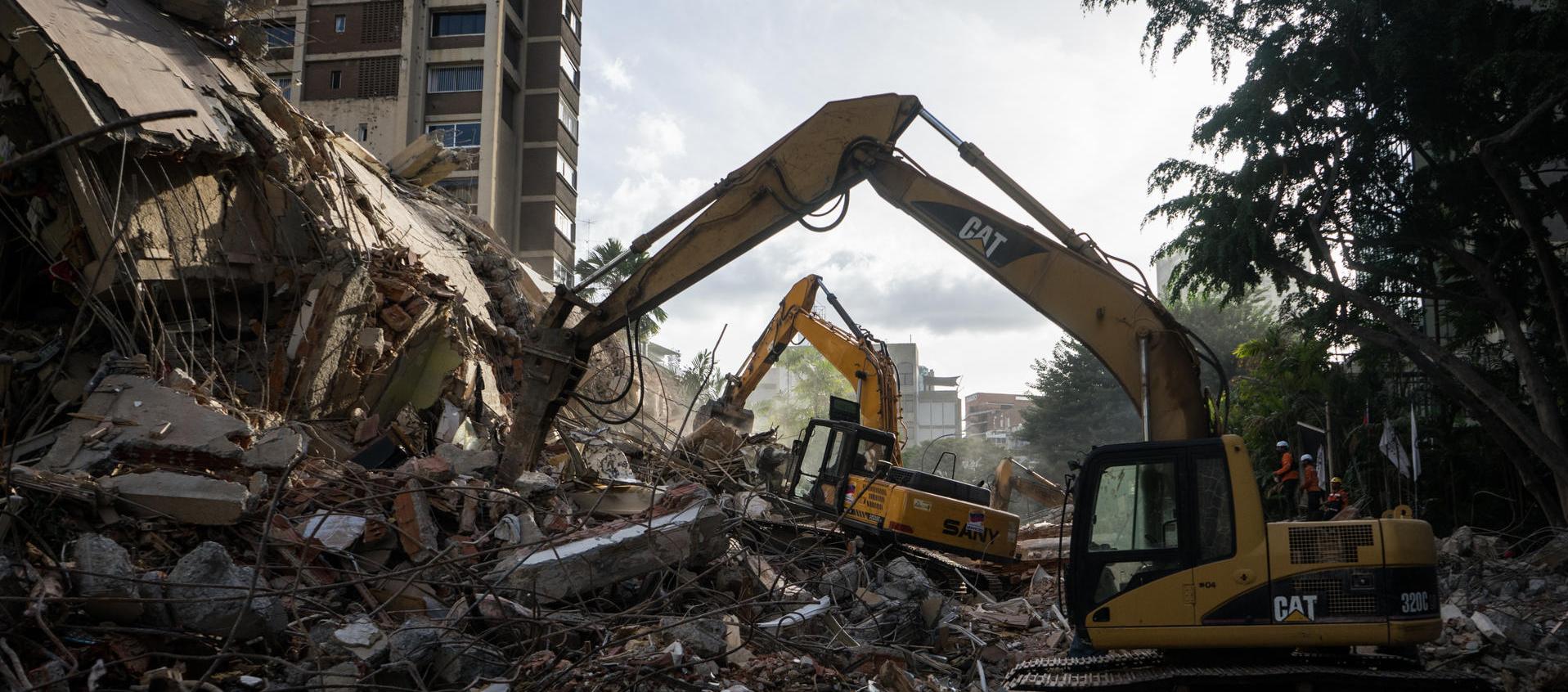 Integrantes de equipos de rescate trabajan en un edificio afectado.