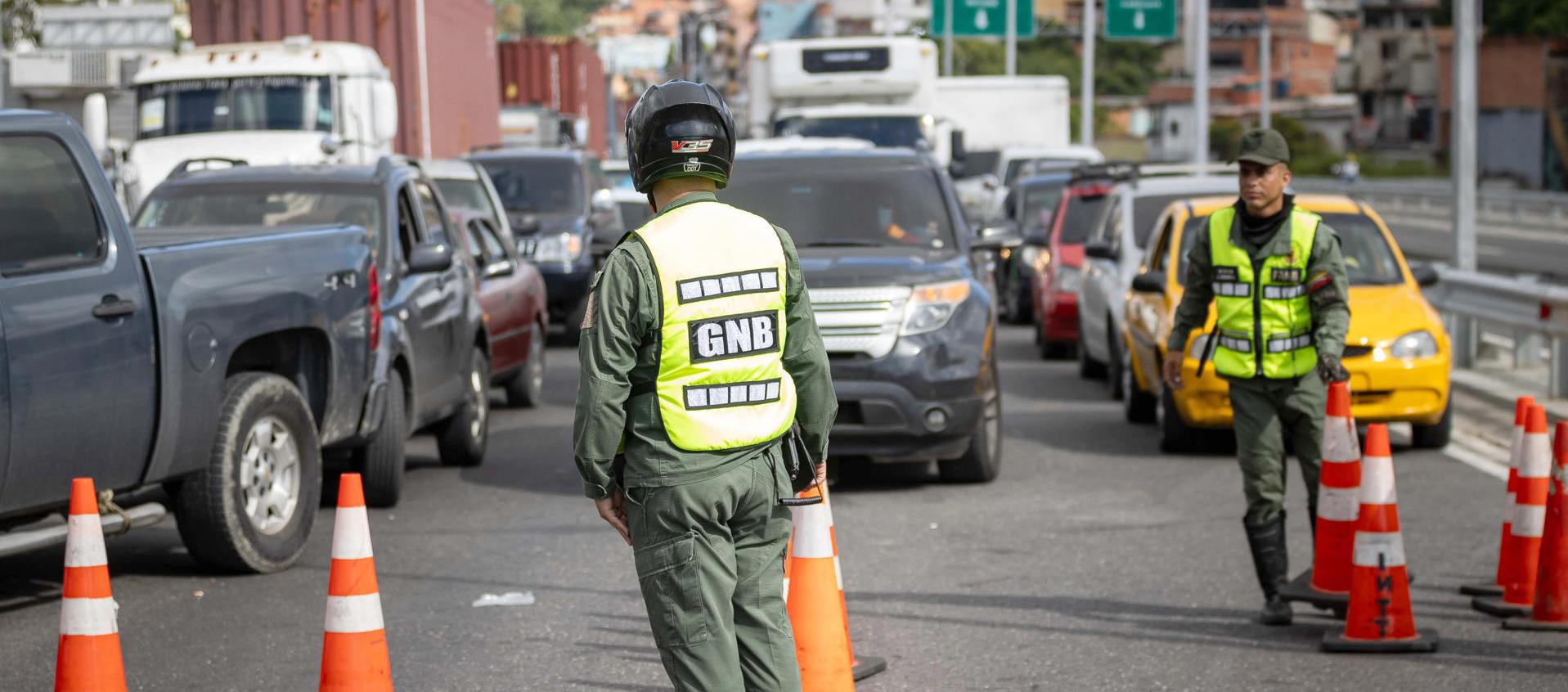Integrantes de la Guardia Nacional Bolivariana custodian en la autopista bloqueada que conecta al estado La Guaira con Caracas.