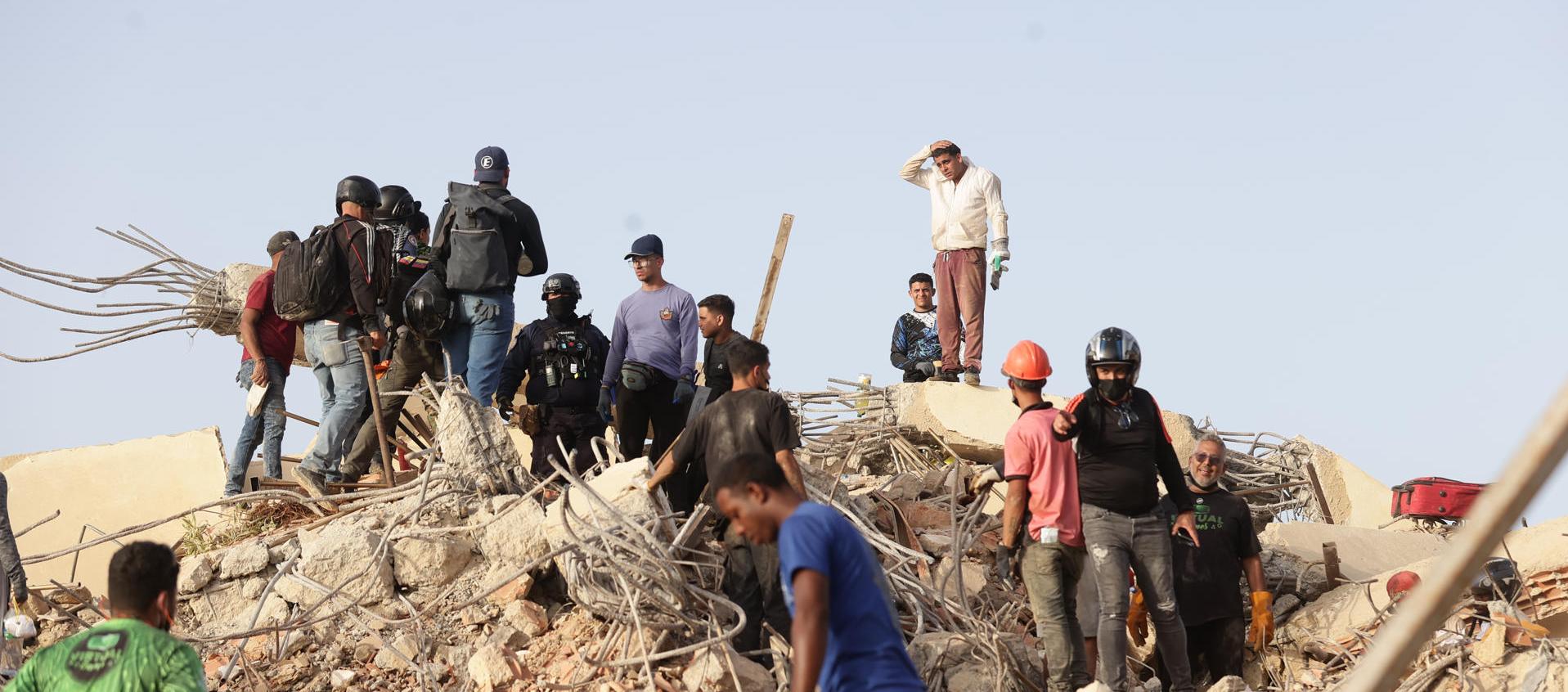 Personas realizan labores de búsqueda en una zona afectada por los terremotos, en La Guaira.