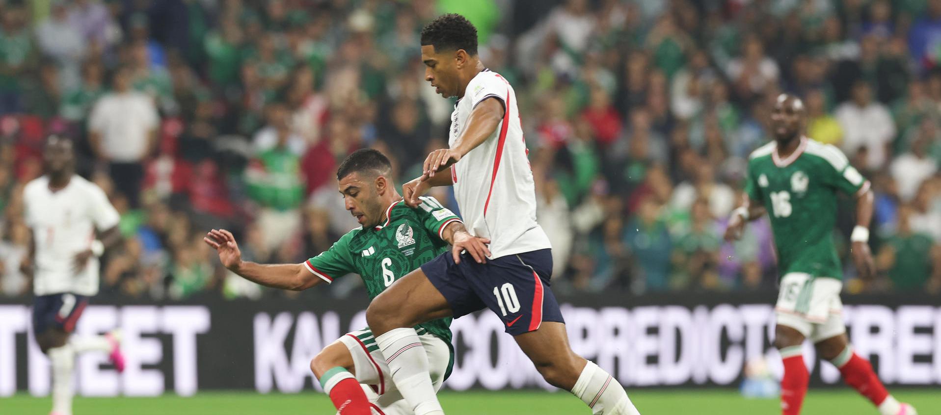  Erik Lira (i) de México disputa un balón con Jude Bellingham de Inglaterra