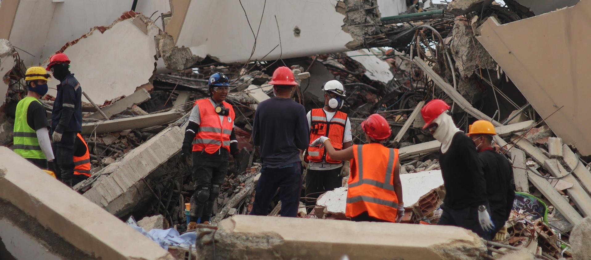 Voluntarios en una edificación destruida por los terremotos.