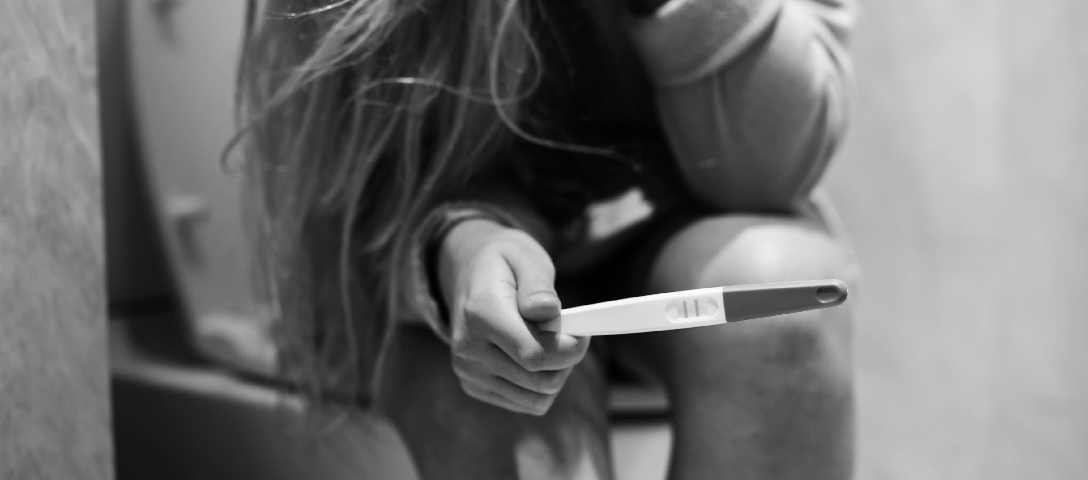 Una mujer deprimida con una prueba de embarazo positiva