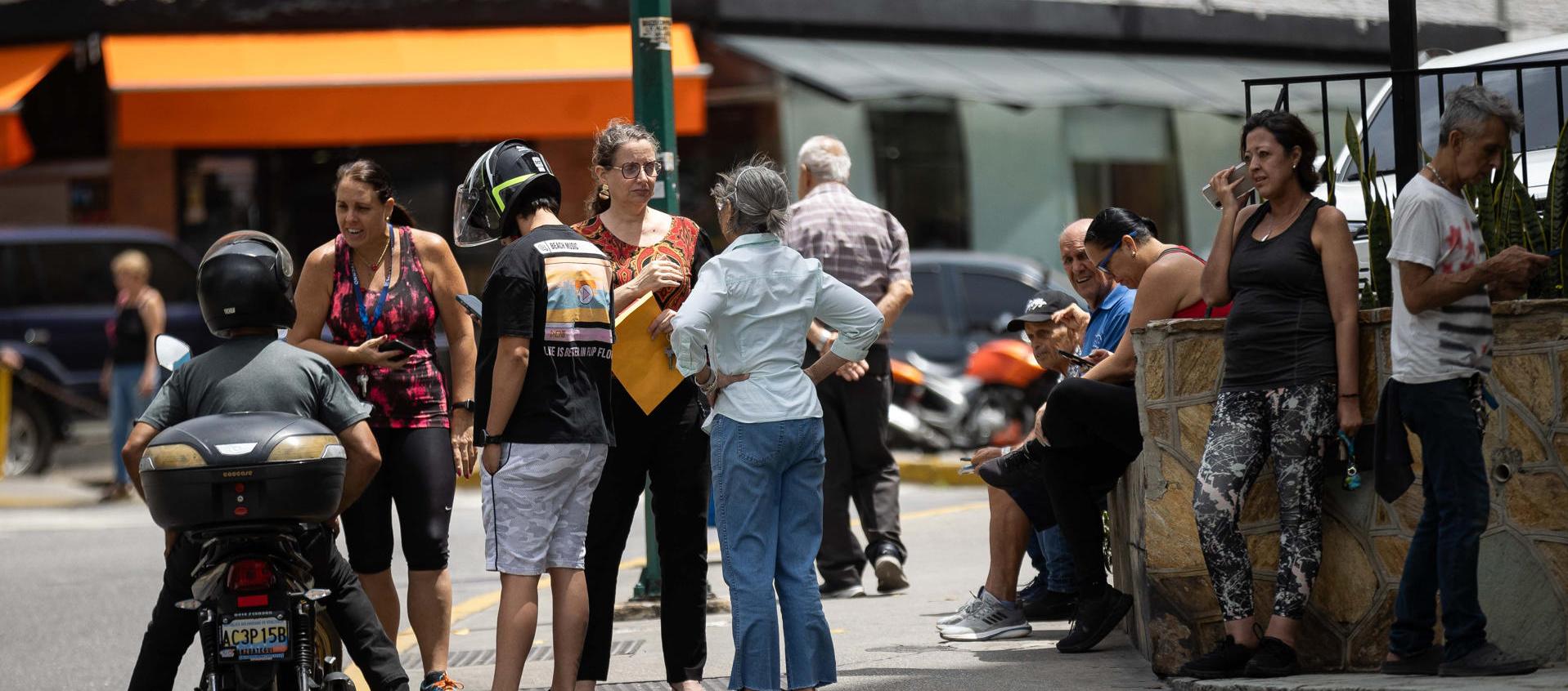 Personas esperan afuera de sus viviendas este viernes. 