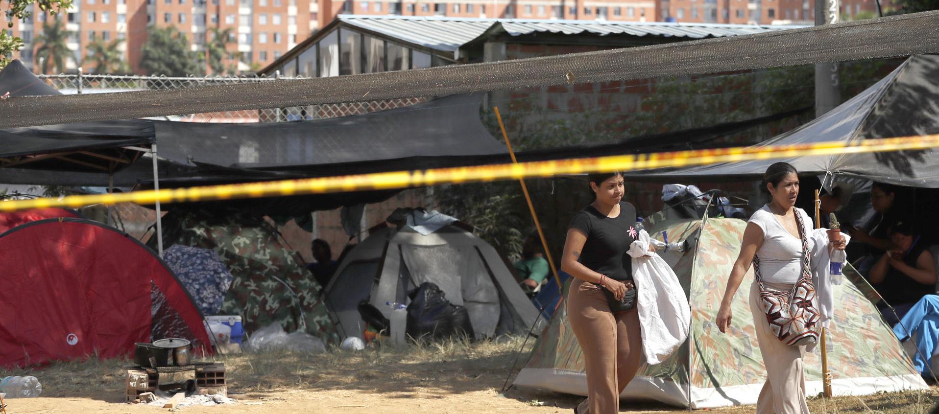 Personas esperan en carpas este jueves, junto al edificio Reserva de Meléndez, en Cali.