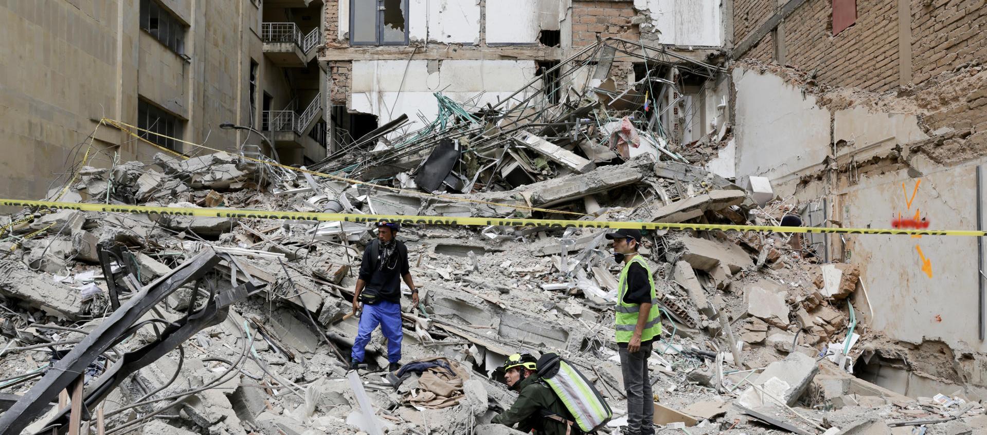 Personas observan los escombros de un edificio afectado por el terremoto en Pereira. 