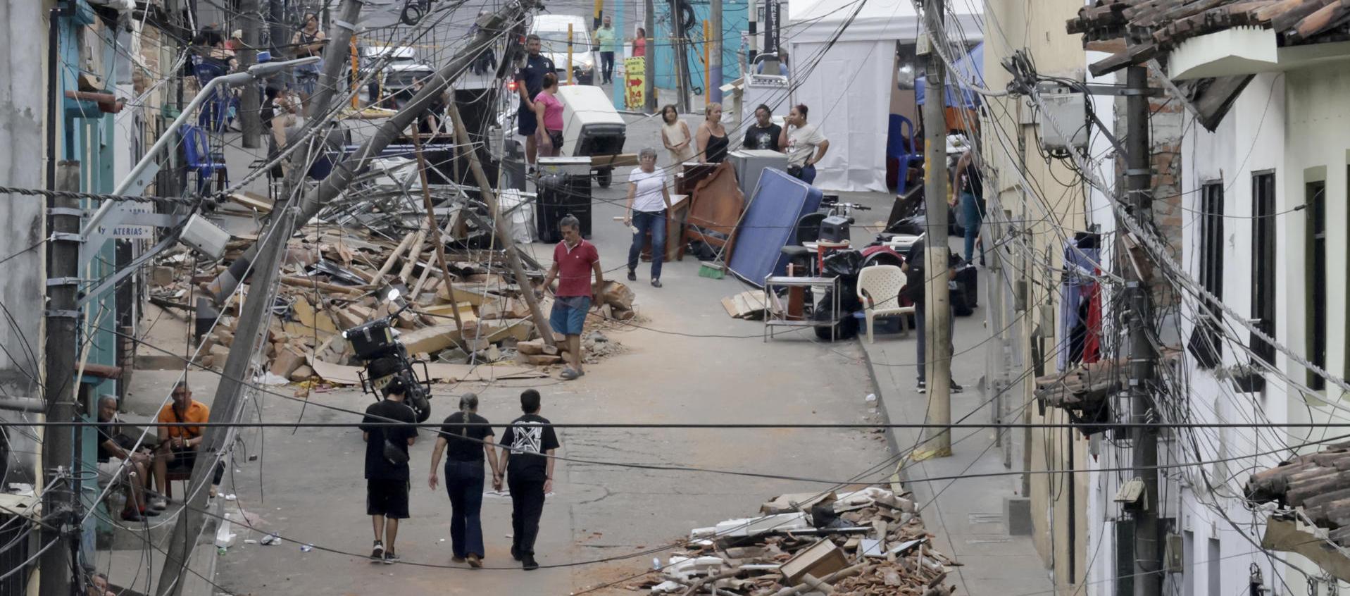 Personas caminan frente a edificaciones afectadas por el terremoto en Pereira.