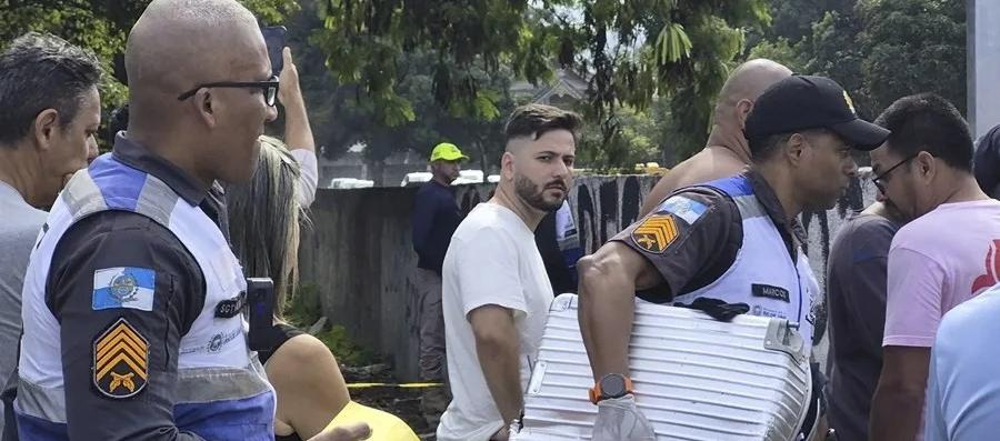 Policía transporta una maleta recuperada en el lugar donde ocurrió el accidente de dos helicóptero
