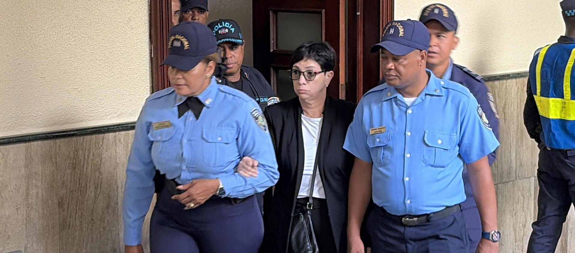 Policías custodian a Maribel Espaillat, a su llegada a la sala de audiencias este viernes en Santo Domingo