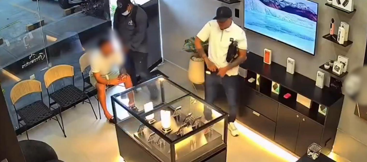 Los dos delincuentes cuando robaban el local de celulares. 