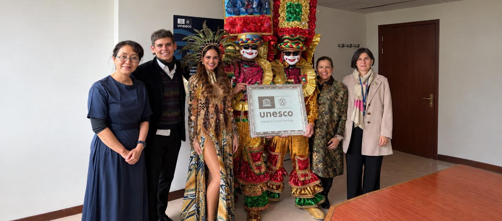 La reina del Carnaval 2027 Salwa Maloof, junto a los miembros de la Unesco, la directora de Carnaval Diana Acosta y hacedores.