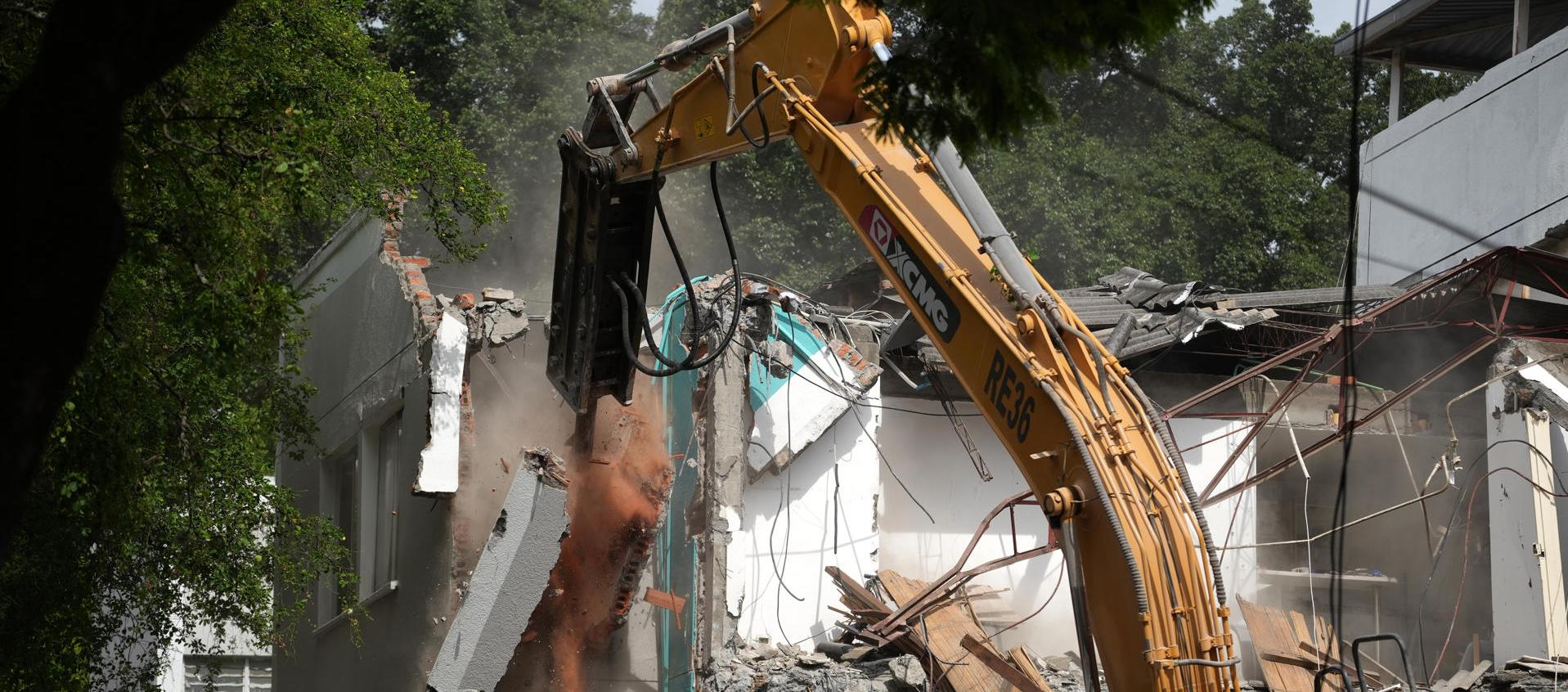 Retroexcavadora demoliendo un edificio.