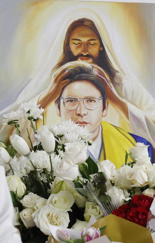 Una persona pone flores en un altar durante la conmemoración del primer aniversario del atentado contra Miguel Uribe Turbay en Bogotá.