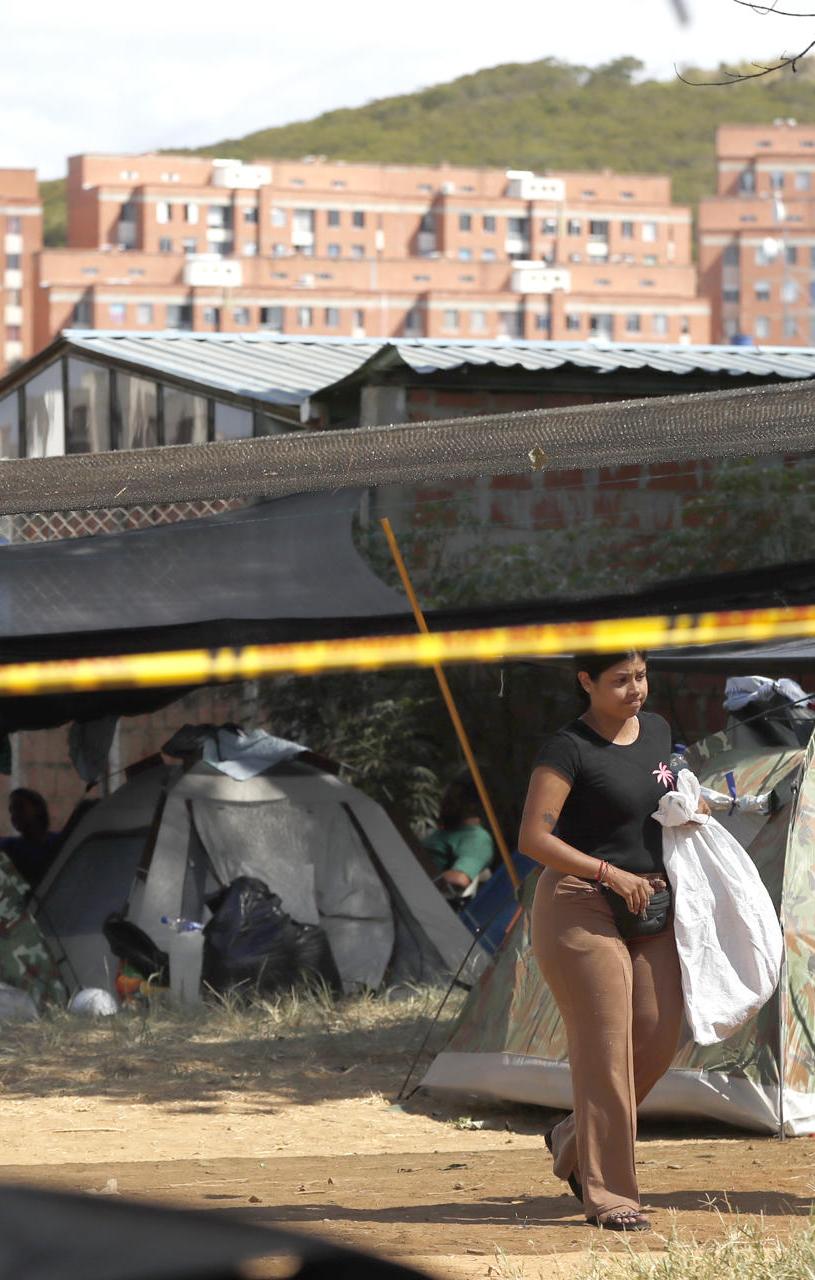 Personas esperan en carpas este jueves, junto al edificio Reserva de Meléndez, en Cali.