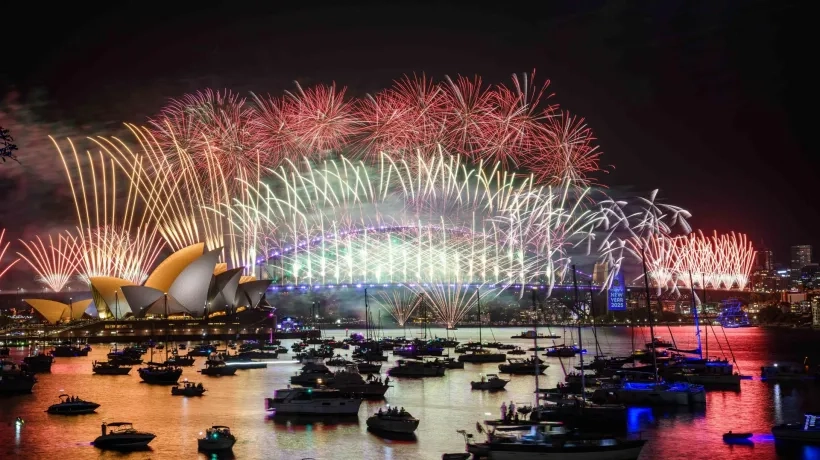 Fuegos artificiales iluminan el cielo sobre la Ópera de Sídney y el Puente del Puerto como parte de las primeras celebraciones.