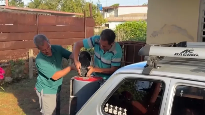 El cubano colocando el carbón para que el vehículo funcione. 